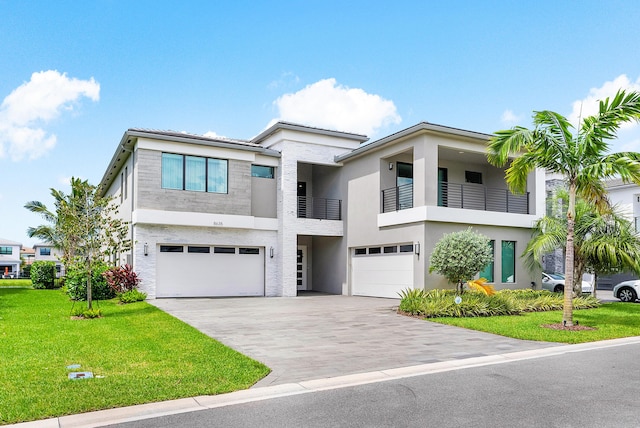 contemporary house featuring a balcony, a garage, and a front yard