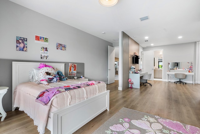 bedroom featuring built in desk and light hardwood / wood-style flooring