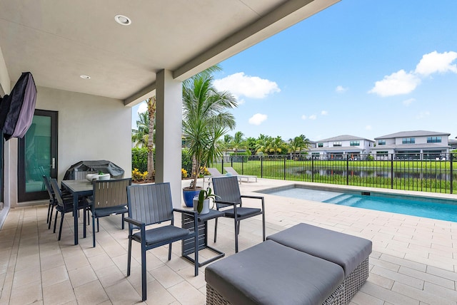 view of patio / terrace featuring a water view and a fenced in pool