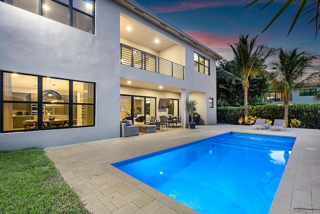 pool at dusk with a patio