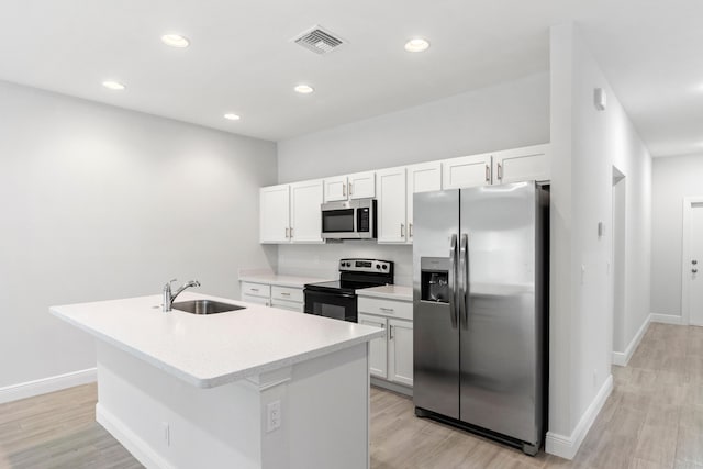 kitchen featuring sink, white cabinetry, an island with sink, and appliances with stainless steel finishes