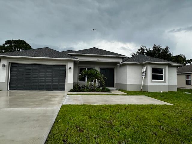 view of front of house featuring a garage and a front lawn