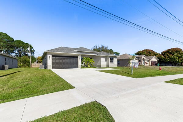 ranch-style house featuring a garage and a front lawn