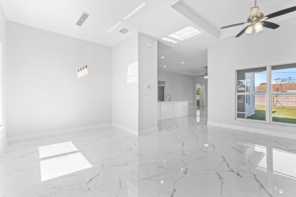 empty room featuring a raised ceiling and ceiling fan