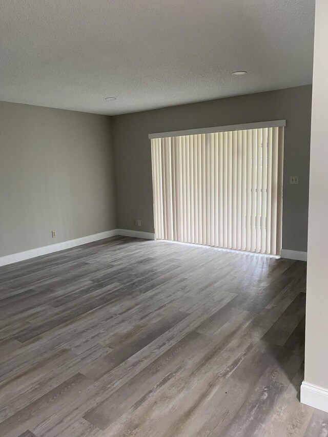 spare room featuring a textured ceiling and hardwood / wood-style flooring