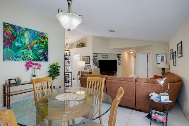 tiled dining area featuring vaulted ceiling