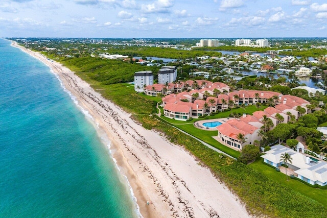 birds eye view of property with a water view and a beach view