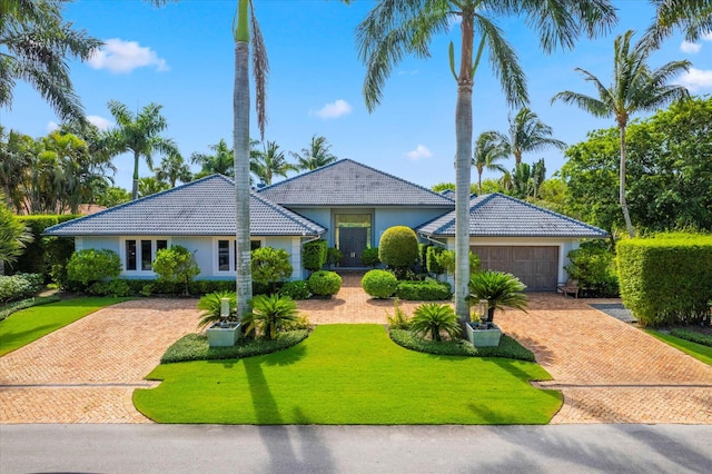 ranch-style house with a garage and a front yard