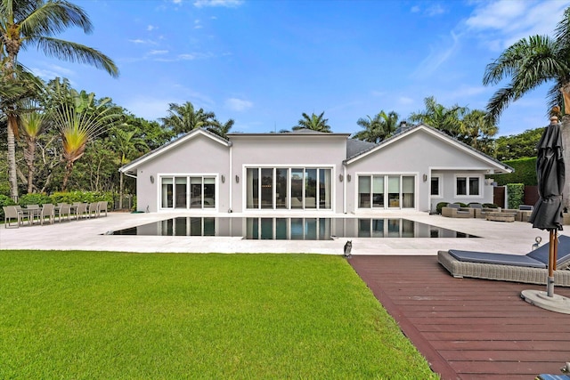 back of house featuring an outdoor living space, a lawn, and a patio