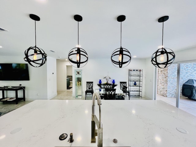 details featuring light stone counters and pendant lighting