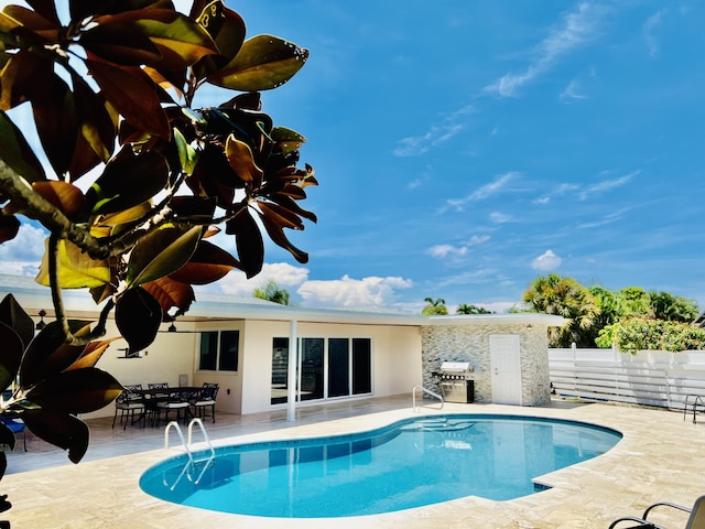 view of swimming pool featuring a grill and a patio area