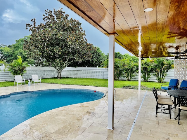 view of pool with a patio area and a yard