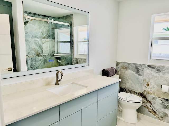 bathroom with vanity, toilet, and a shower with door