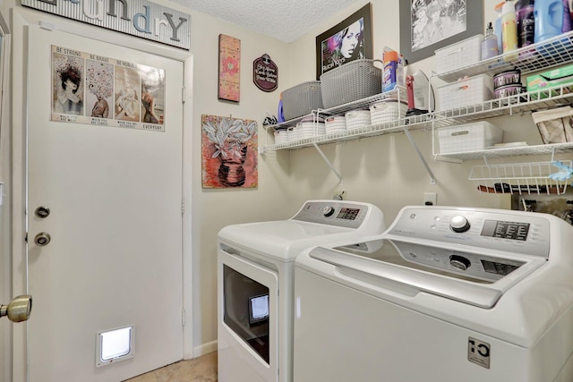 laundry area featuring washer and clothes dryer and a textured ceiling