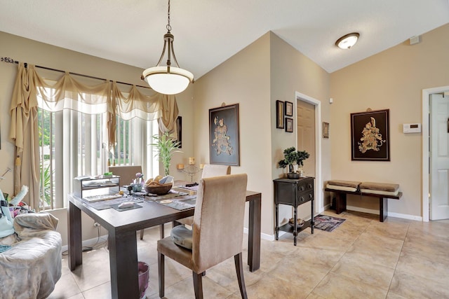 tiled dining room with lofted ceiling