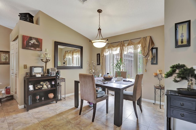 tiled dining area featuring lofted ceiling and a textured ceiling