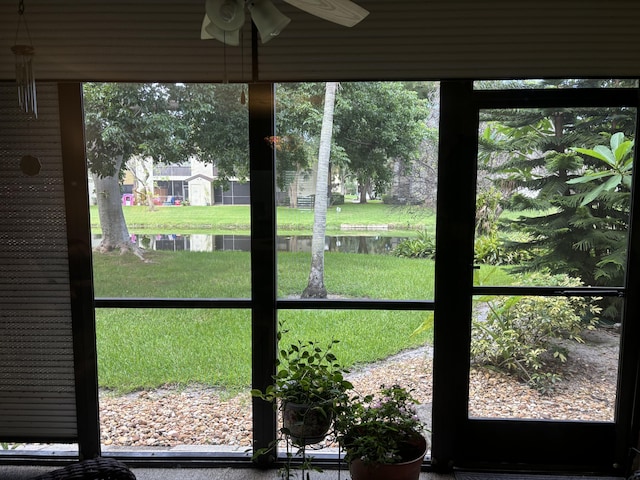 sunroom featuring a water view