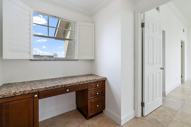 unfurnished office featuring built in desk, ornamental molding, and light tile patterned floors