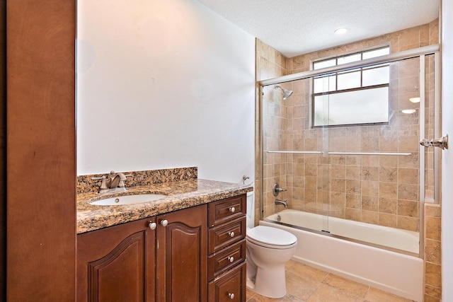 full bathroom with toilet, a textured ceiling, vanity, and shower / bath combination with glass door