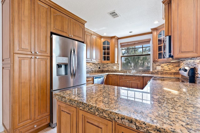 kitchen with appliances with stainless steel finishes, sink, decorative backsplash, dark stone counters, and a textured ceiling