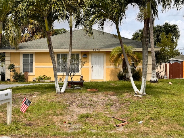 ranch-style home with a storage shed and a front lawn