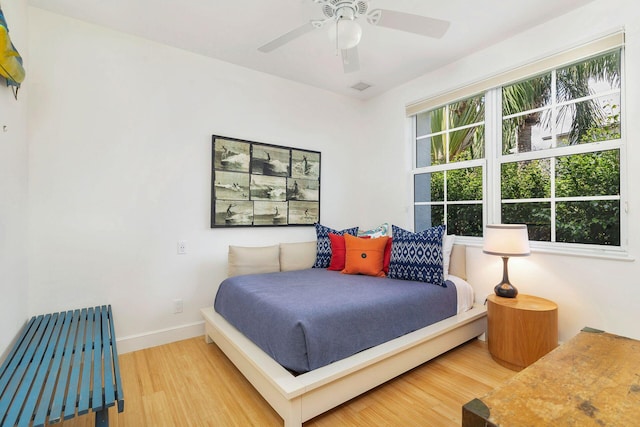 bedroom featuring hardwood / wood-style flooring, multiple windows, and ceiling fan