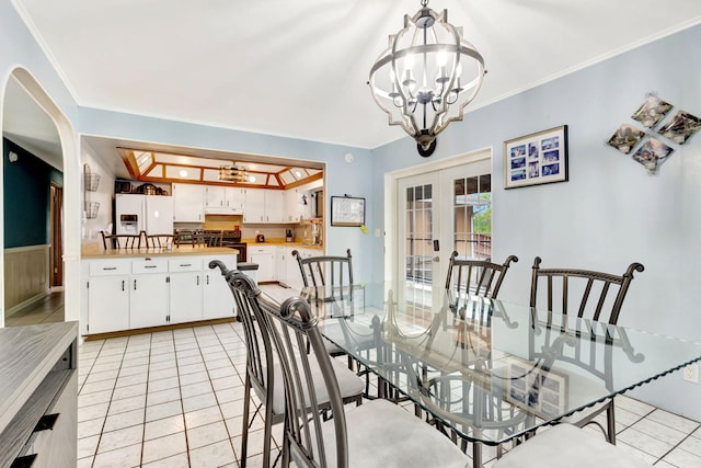 dining area featuring an inviting chandelier, light tile patterned floors, crown molding, and french doors