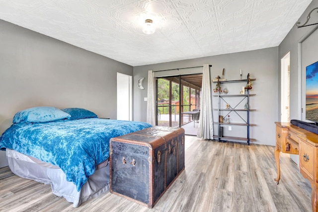 bedroom with access to exterior and light wood-type flooring