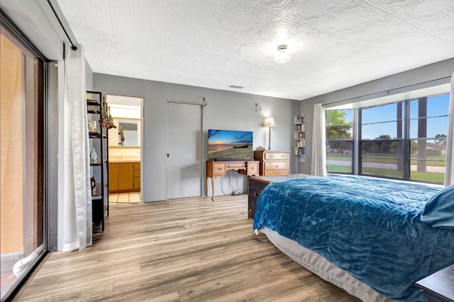 bedroom featuring hardwood / wood-style flooring and connected bathroom