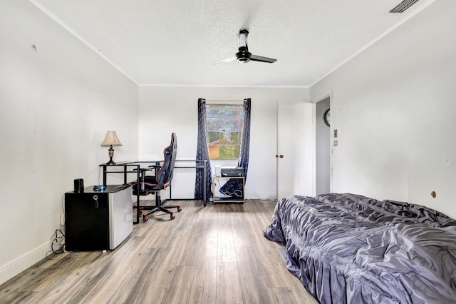 bedroom featuring a textured ceiling, ceiling fan, and wood-type flooring