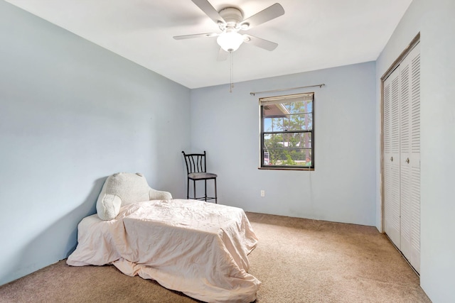 carpeted bedroom with ceiling fan and a closet