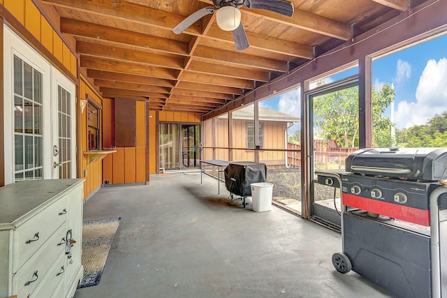 sunroom with ceiling fan and beamed ceiling