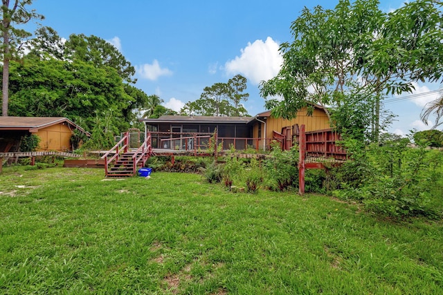 back of house featuring a wooden deck, a sunroom, and a yard