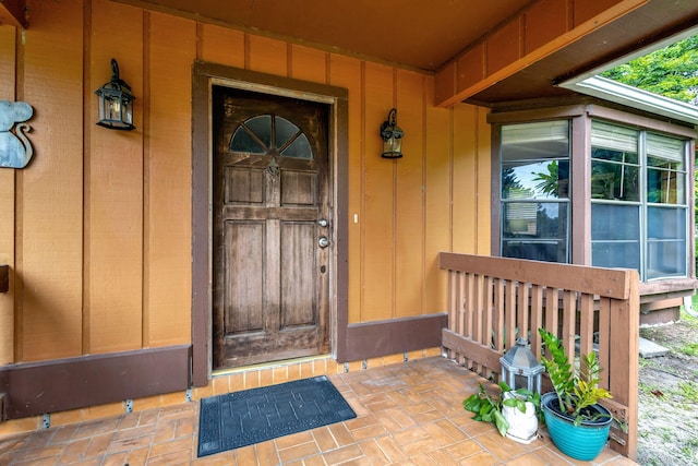 view of exterior entry featuring covered porch