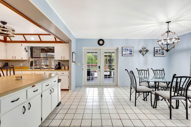 kitchen with hanging light fixtures, white cabinets, french doors, and light tile patterned floors