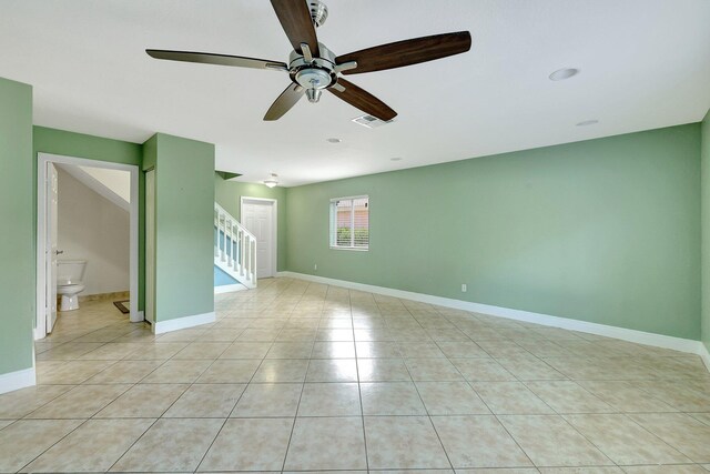 tiled spare room featuring ceiling fan