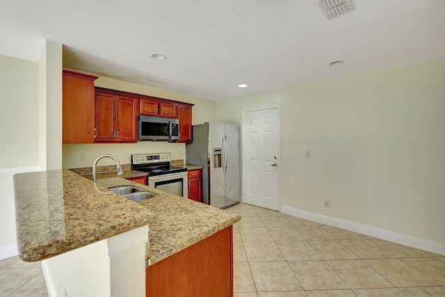 kitchen with light tile patterned floors, sink, kitchen peninsula, stainless steel appliances, and light stone countertops