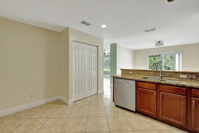 kitchen with light tile patterned floors, sink, a textured ceiling, dishwasher, and dark stone counters