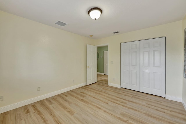 unfurnished bedroom featuring light hardwood / wood-style flooring and a closet