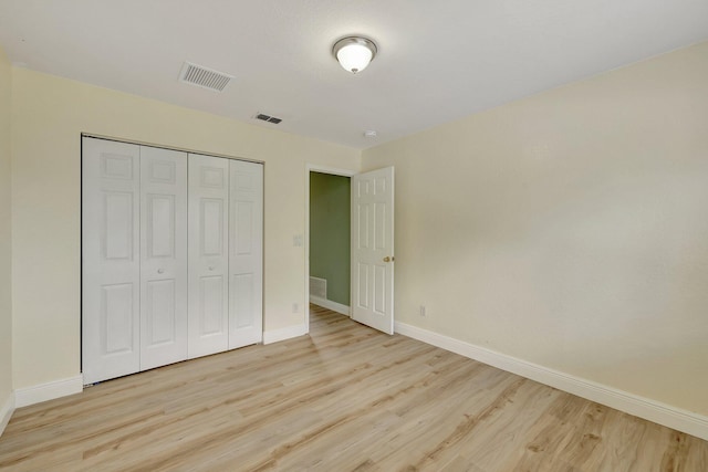 unfurnished bedroom featuring a closet and light hardwood / wood-style floors