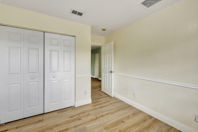 unfurnished bedroom with light wood-type flooring and a closet