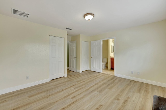 unfurnished bedroom featuring connected bathroom and light hardwood / wood-style floors