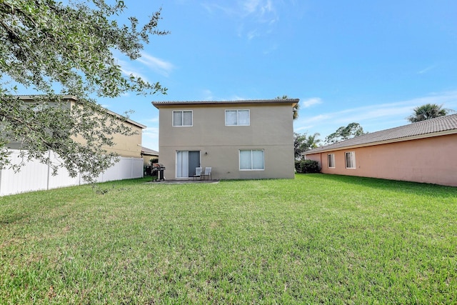 rear view of house featuring a yard