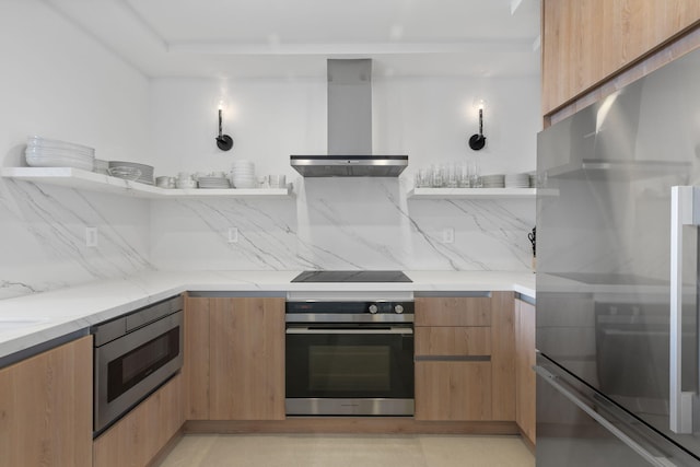 kitchen with decorative backsplash, light stone countertops, wall chimney exhaust hood, and appliances with stainless steel finishes