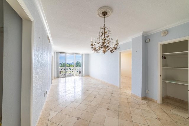 tiled spare room with crown molding, a textured ceiling, a chandelier, and expansive windows