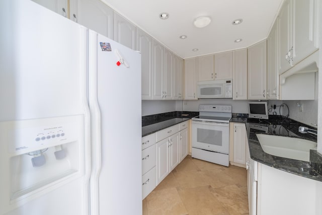 kitchen with sink, white cabinets, white appliances, and dark stone counters