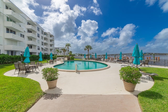 view of pool with a patio area and a lawn