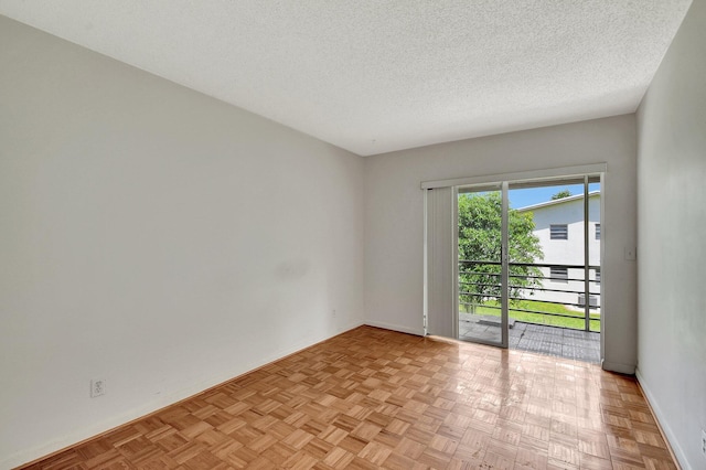 spare room with a textured ceiling and light parquet floors