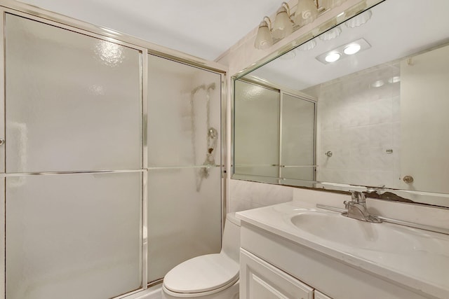 bathroom with vanity, toilet, and a shower with door