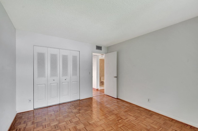 unfurnished bedroom with a textured ceiling and light parquet floors